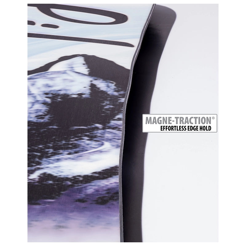 Close-up of a snowboard edge showing the black base, a printed mountain graphic in black, white, and purple, and a white label that reads MAGNE-TRACTION EFFORTLESS EDGE HOLD.