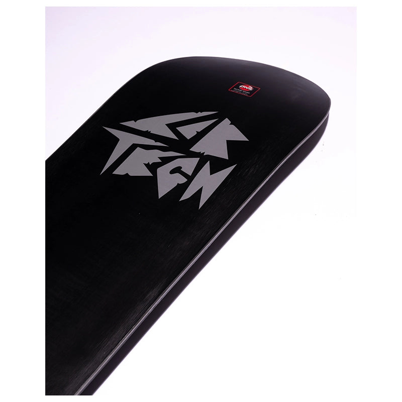 A close-up of a black snowboard deck featuring a large silver stylized logo and a small red square brand sticker near the nose, set against a plain white background.