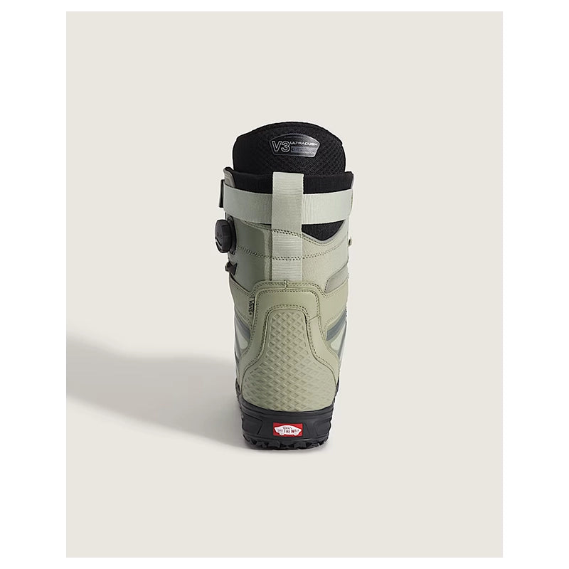 A single Vans snowboard boot shown from the back on a light beige background. The boot features a light sage green upper with black accents, including the collar, sole, and dial closure system.