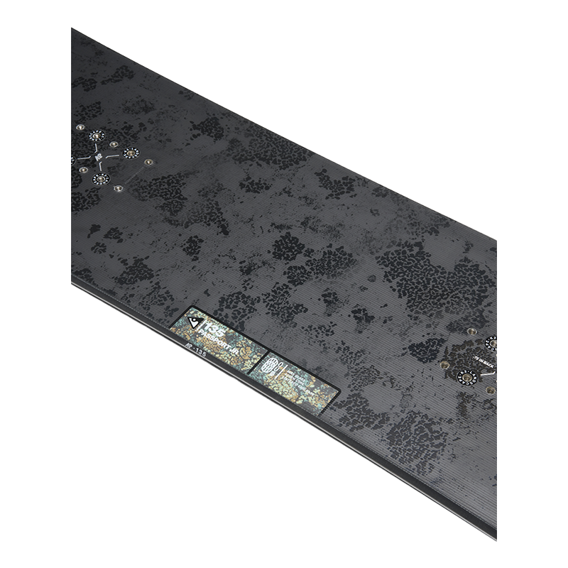 A long, thin rectangular product shown at an angle on a plain white background. The surface is dark charcoal gray with a mottled, textured pattern and a small multicolor label or patch near one end.