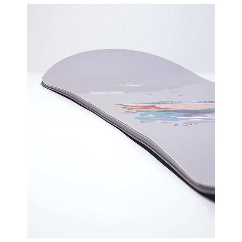A close-up of a snowboard deck showing the base with a light gray finish and a colorful graphic near the tail, photographed on a clean white background.