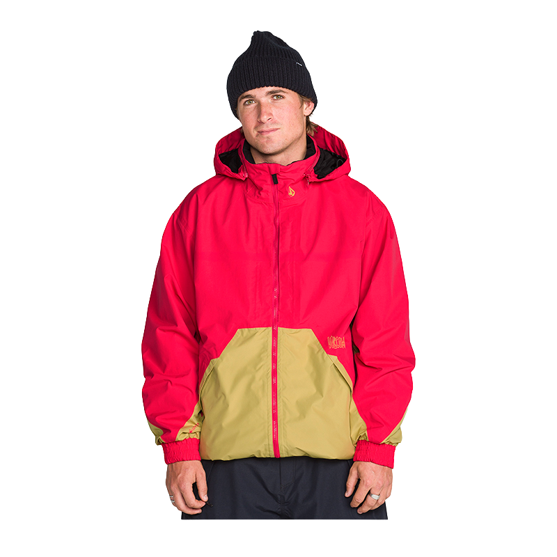 A man wearing a red and tan color-blocked hooded jacket, a black beanie, and dark pants, standing against a solid white background.