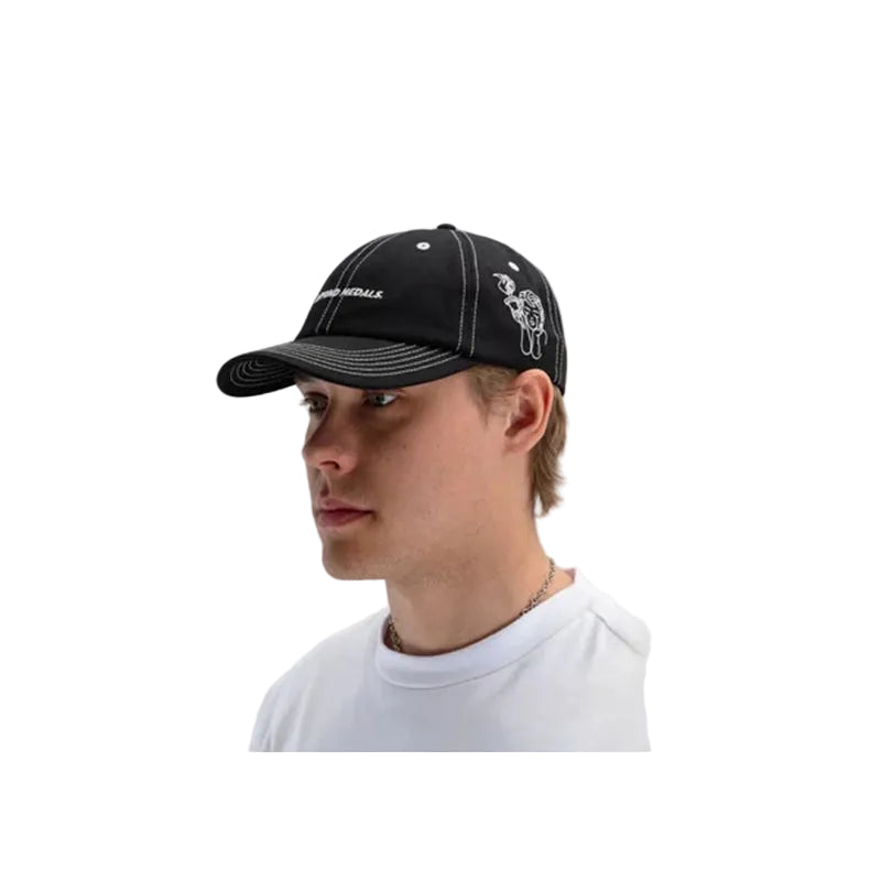 A man in a white t-shirt wearing a black baseball cap with white embroidery, shown in profile against a light gray background.