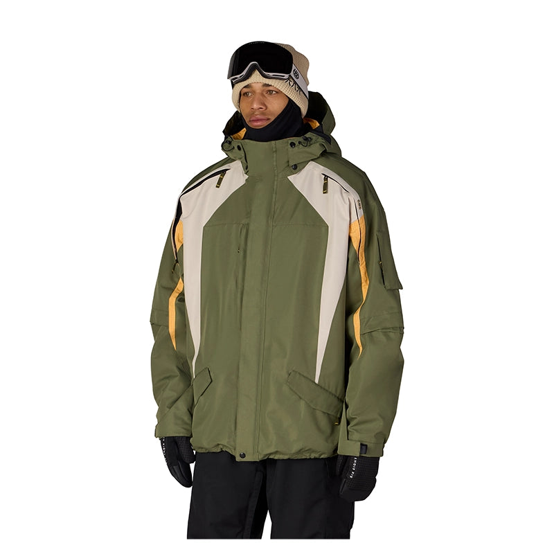 A man wearing an olive green ski jacket with cream and yellow accents, black snow pants, black gloves, and a beige beanie with goggles, photographed against a solid white background.