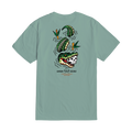 A sage green short-sleeve t-shirt shown from the back, featuring a graphic of a skull-headed alligator, green watermelons, and orange flowers with the text 'DARK SEAS' and 'MONTREAL' printed below.