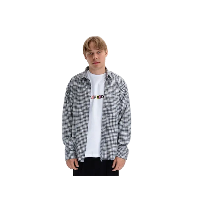 A young man modeling a black and white checkered button-up shirt over a white t-shirt with a colorful graphic, set against a plain light gray background.