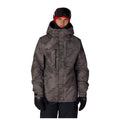 A man wearing a dark gray and black camouflage ski jacket, black snow pants, black gloves, and a red and black beanie with goggles, photographed against a solid white background.