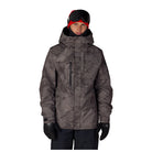 A man wearing a dark gray and black camouflage ski jacket, black snow pants, black gloves, and a red and black beanie with goggles, photographed against a solid white background.