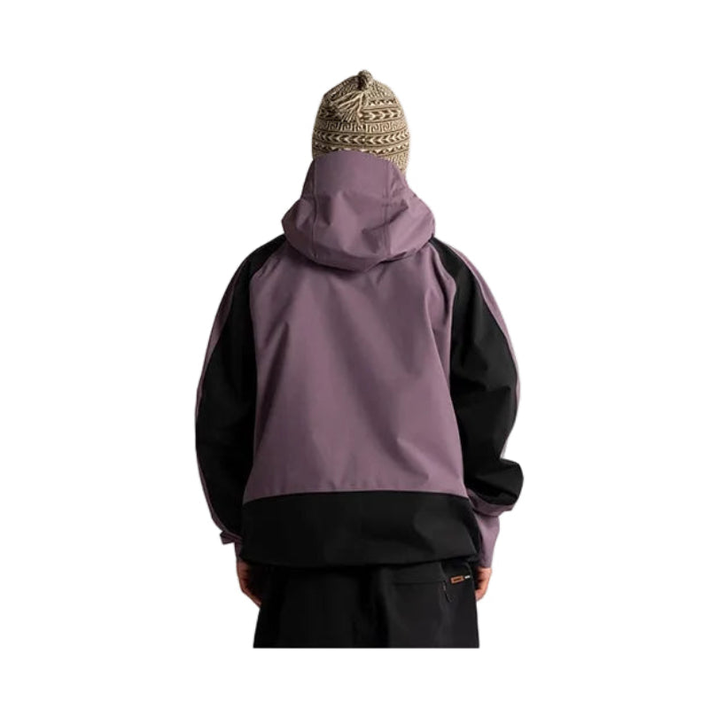 A person shown from the back wearing a color-blocked hooded jacket with a dusty purple body and black sleeves and hem, paired with a patterned knit beanie against a plain white background.