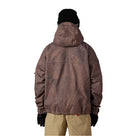 A person shown from the back wearing a brown hooded jacket with an allover tonal camouflage-like pattern, black beanie, black gloves, and tan pants against a plain white background.