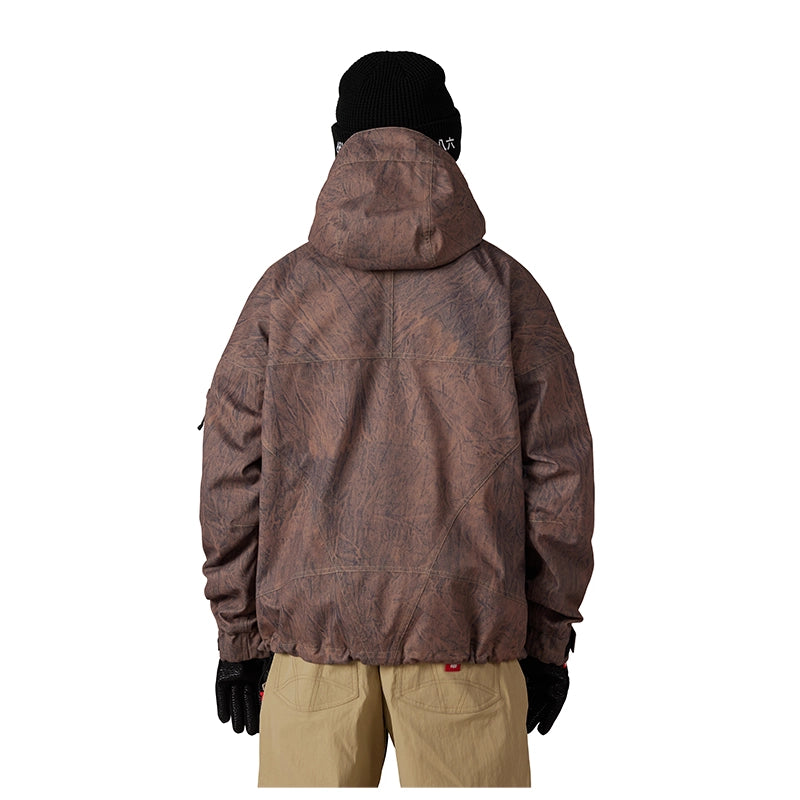 A person shown from the back wearing a brown hooded jacket with an allover tonal camouflage-like pattern, black beanie, black gloves, and tan pants against a plain white background.