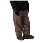 A person wearing brown patterned snow pants, a black jacket, and black gloves, shown from the waist down against a plain white background.
