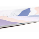 A close-up of a printed item, likely a notebook, journal, or booklet, showing a pastel abstract design with the brand name 'POWERPODS' printed on the side. The design features soft lavender, dusty blue, peach, and white wavy shapes.