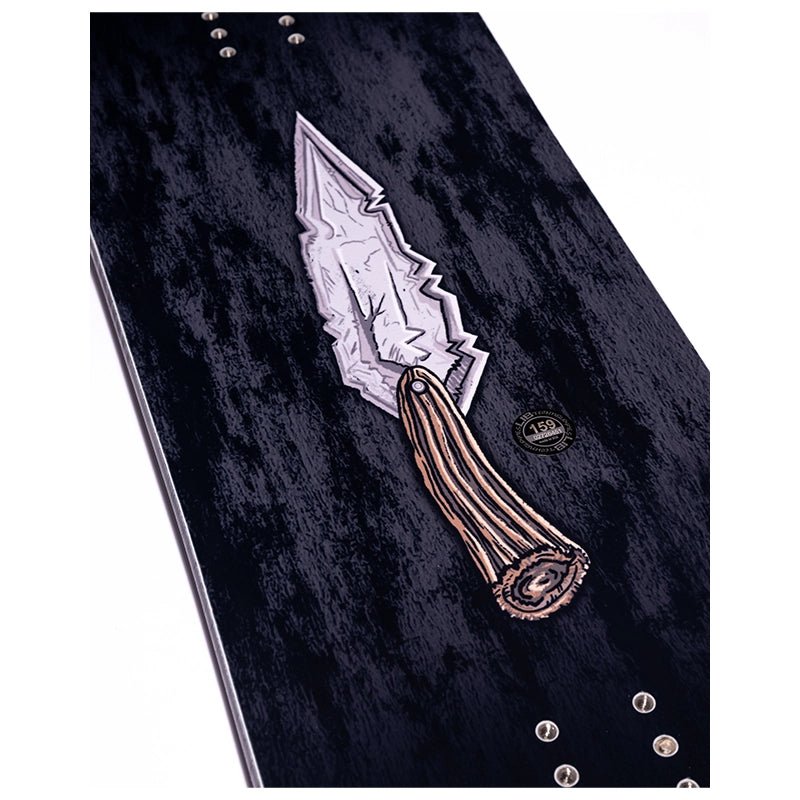 A close-up of a dark textured surface featuring a decorative silver and bronze knife motif with metallic studs, on a white background.