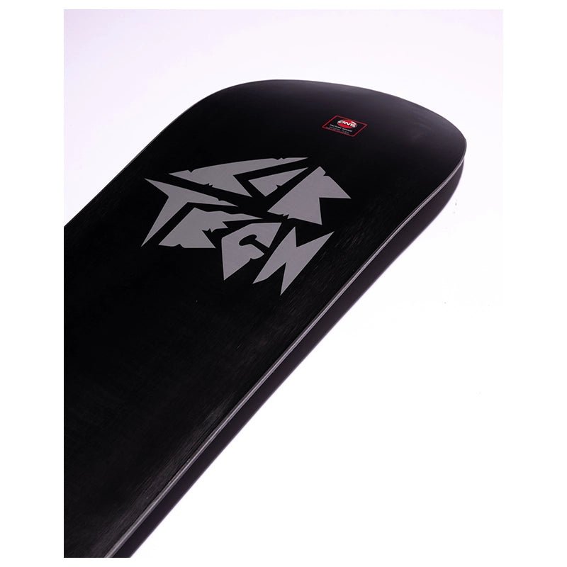 A close-up of a black snowboard deck featuring a large silver stylized logo and a small red square brand sticker near the nose, set against a plain white background.