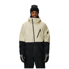 A man wearing a colorblock snowboard jacket in off-white and black, paired with a black beanie, black gloves, and black snow pants, photographed against a solid white background.
