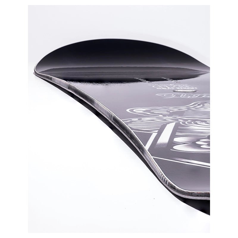 Close-up of a black snowboard showing the base graphic and edge profile against a white background.