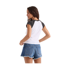 A woman shown from the back wearing a white and dark gray raglan baseball t-shirt and blue denim shorts with a frayed hem, set against a plain white background.