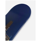 Close-up of a snowboard deck showing the blue base with a small portion of a graphic and metal binding hardware, photographed on a light gray background.