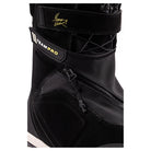 Close-up of a black snowboard boot with a strap closure featuring a gold signature logo and a black strap with 'TEAM PRO' text in gold and white.