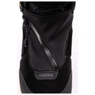 A close-up of a black snowboard boot featuring a diagonal zipper, textured synthetic leather panels, and a 'NITRO' logo badge on the toe area.