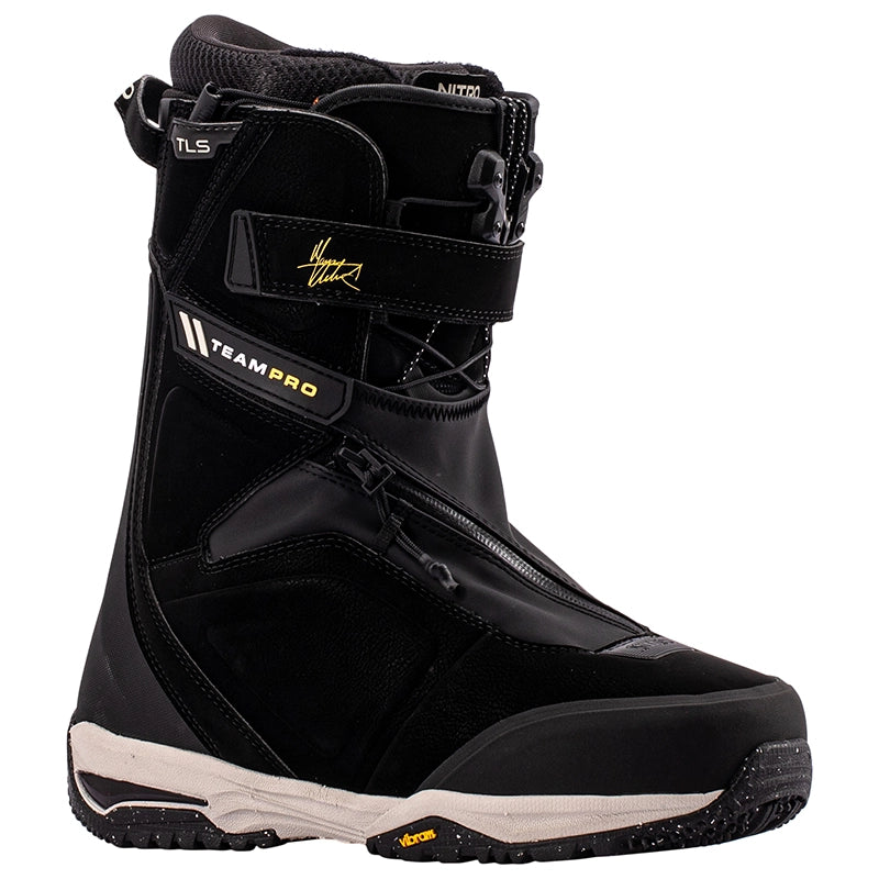 A black Nike snowboard boot with 'TEAM PRO' and 'TLS' branding, featuring a black and white sole with a small yellow Vibram logo, shown against a plain white background.
