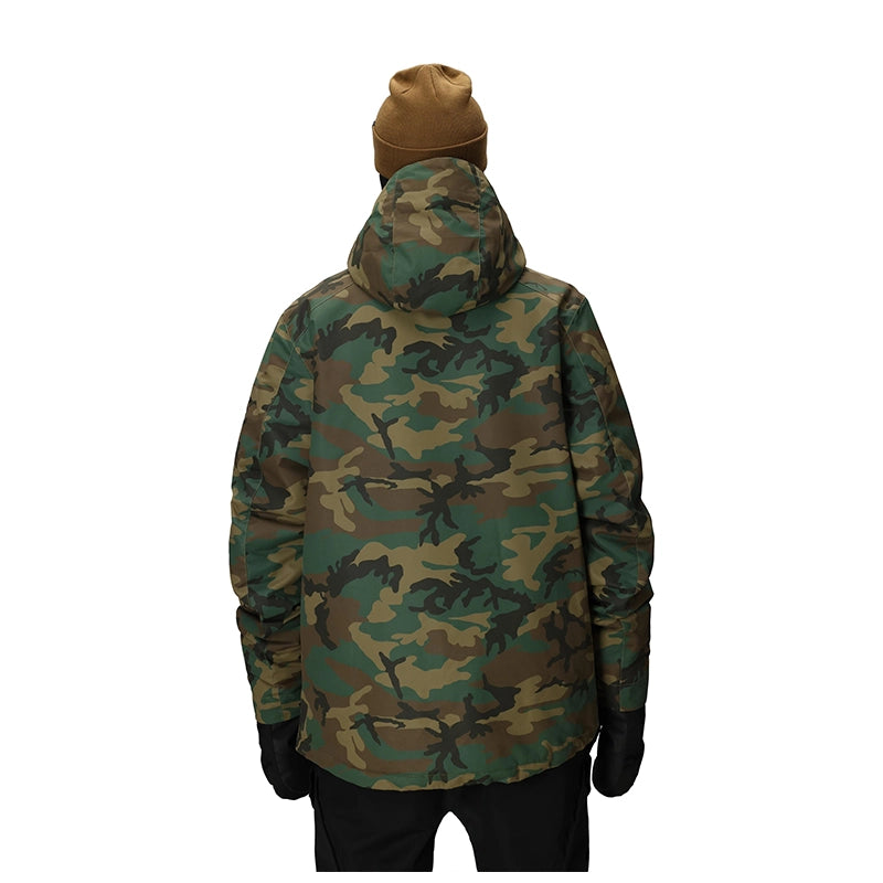 A person shown from the back wearing a hooded camouflage jacket, tan beanie, black gloves, and black pants against a plain white background.