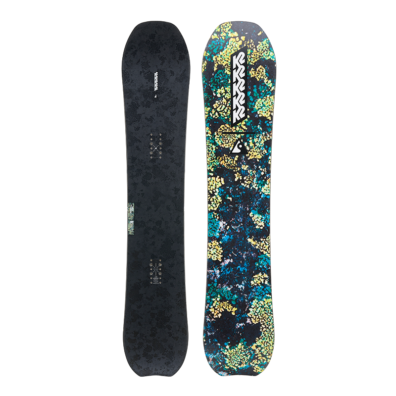 A snowboard shown from both sides against a plain white background. The left side shows the dark charcoal textured base, and the right side shows the colorful top graphic with a blue, green, and yellow floral pattern and the K2 brand logo.