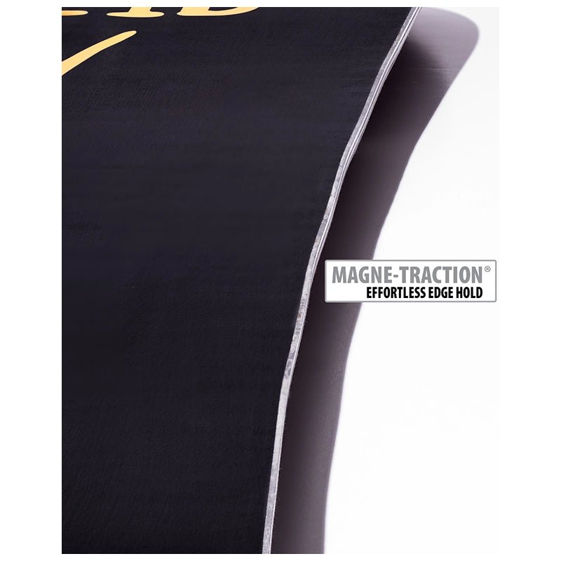 Close-up of a black athletic towel or mat with a white stitched edge and a white label reading 'MAGNE-TRACTION EFFORTLESS EDGE HOLD'.