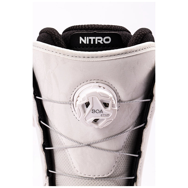 Close-up of a snowboard boot featuring a white BOA dial closure system, light gray suede and mesh panels, black trim, and a black tongue label with the white brand name NITRO.