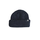 A dark navy blue knit beanie hat with a small white embroidered logo on the folded cuff, shown against a plain white background.