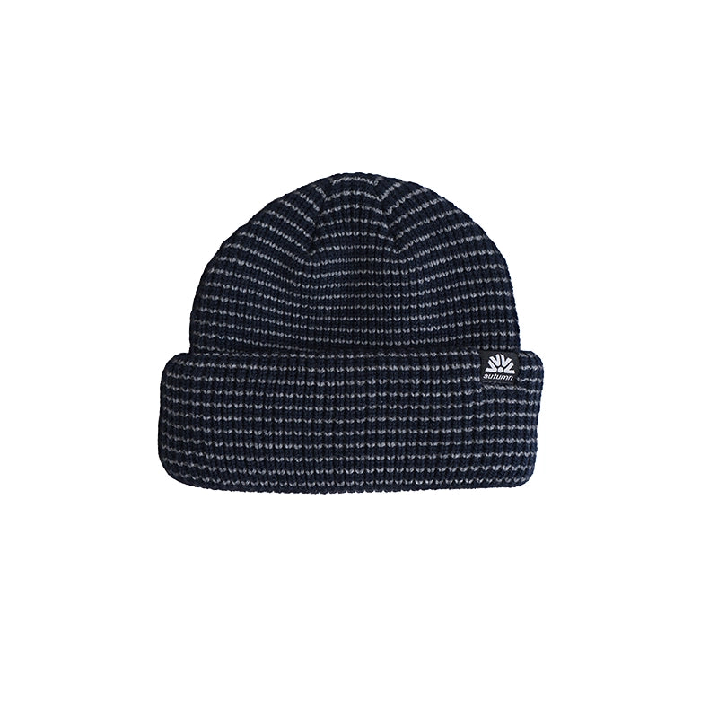 A dark navy blue knit beanie hat with a small white embroidered logo on the folded cuff, shown against a plain white background.