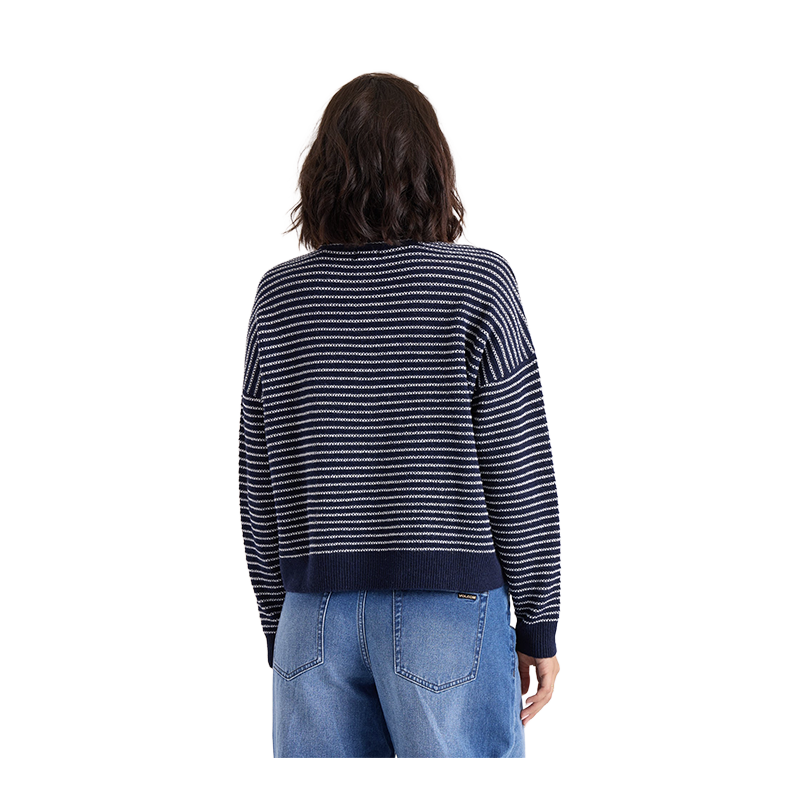 A person shown from the back wearing a navy and white horizontally striped knit sweater with blue jeans, isolated on a solid black background.