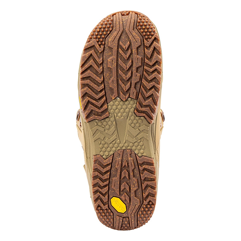 The outsole of a tan and brown boot or shoe, showing deep tread patterns and a small yellow Vibram logo at the heel, isolated on a white background.