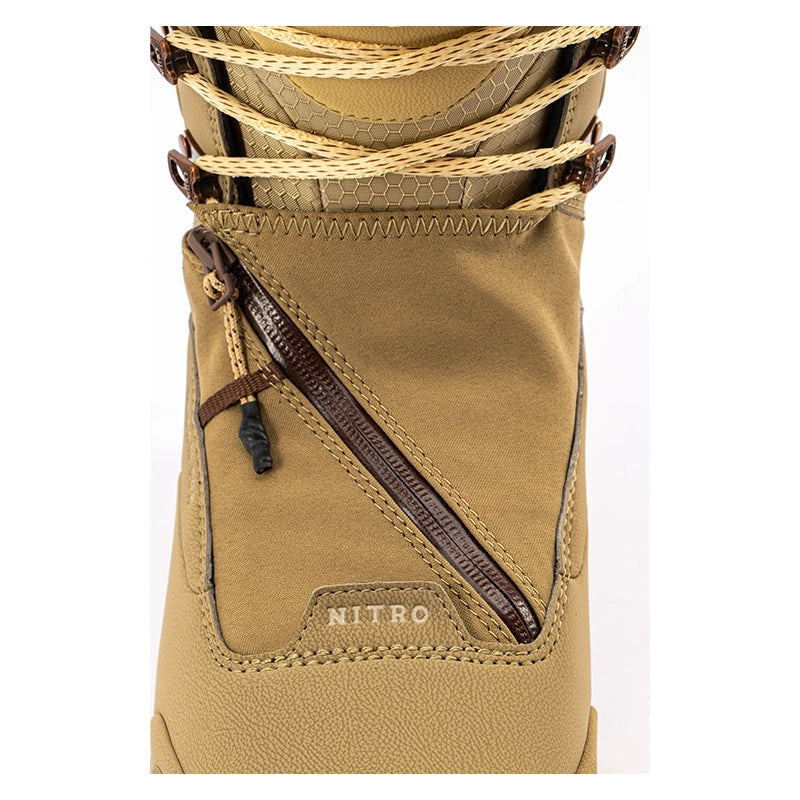 Close-up of a tan technical boot with a diagonal dark brown zipper, tan laces, and a small 'NITRO' logo patch on the side, set against a plain white background.