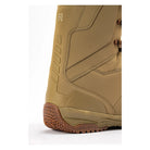 Close-up of the side and heel of a tan snowboard boot with brown laces and a brown treaded sole, shown on a white background.