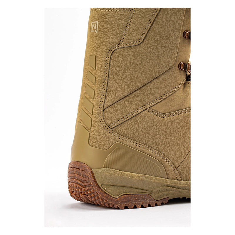 Close-up of the side and heel of a tan snowboard boot with brown laces and a brown treaded sole, shown on a white background.