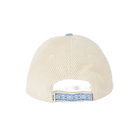 The back of a cream-colored corduroy baseball cap with a light blue patterned strap and a matching light blue button on top.