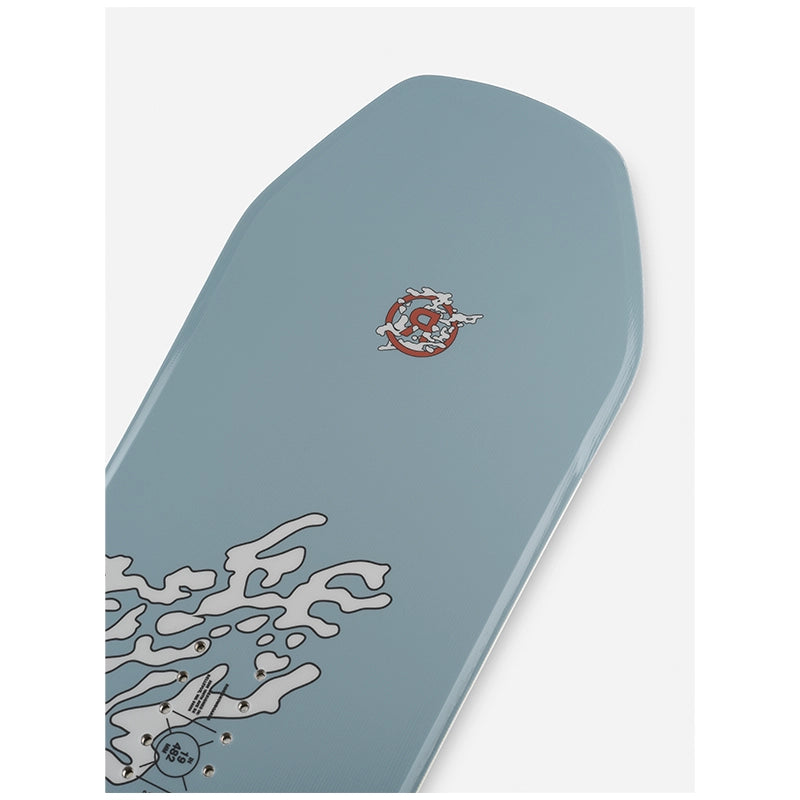 A close-up of a skateboard deck's top sheet, featuring a dusty blue-gray background with a white abstract graphic near the tail and a small red and white logo near the nose.