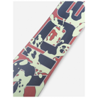 A close-up of a snowboard deck featuring a bold graphic design with navy blue, muted red, and pale cream splatter-like shapes and stylized lettering, photographed on a light gray background.