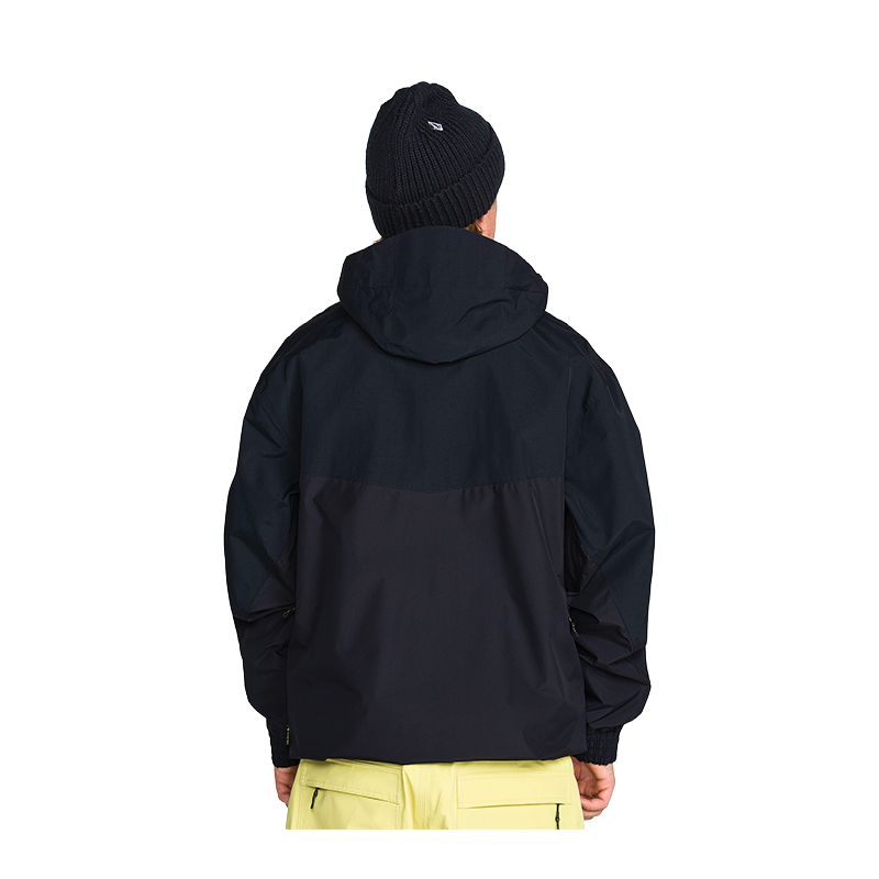A person shown from the back wearing a dark navy hooded jacket, a black knit beanie, and light yellow pants against a plain white background.