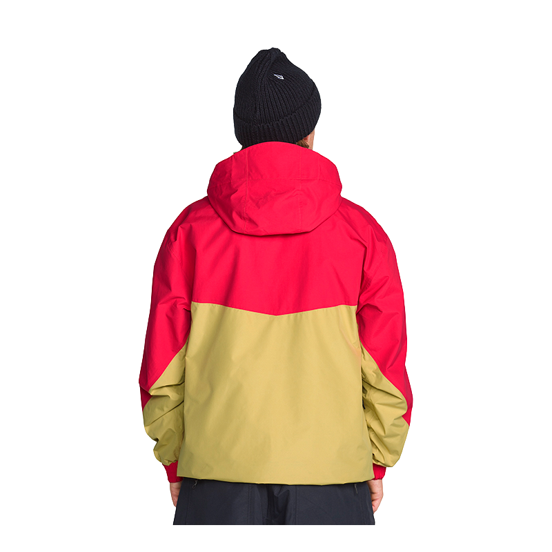 A person shown from the back wearing a colorblock hooded jacket with a bright red upper section and a tan lower section, paired with a black knit beanie against a plain white background.
